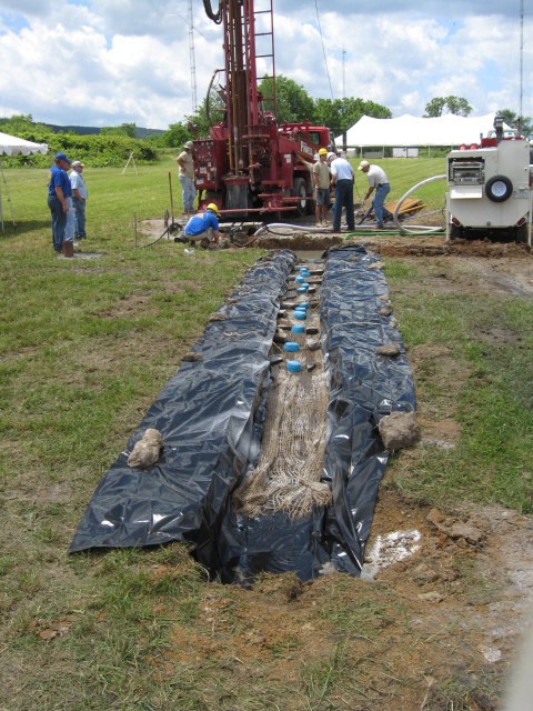 Mixing ditch leading toward drilling rig at State College field conference